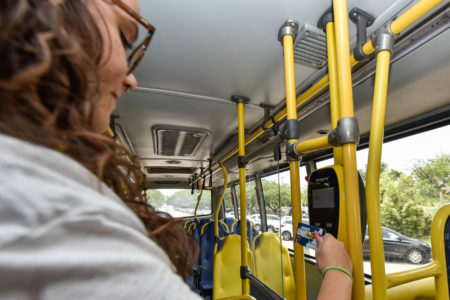 Na foto, uma estudante está com o cartão de bilhete único para passar no leitor e utilizar o transporte coletivo