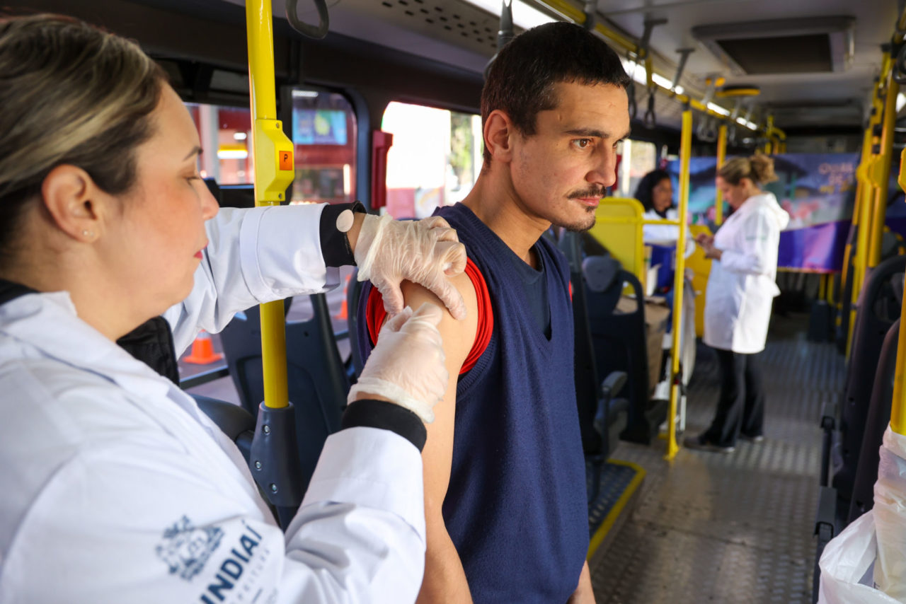 Na imagem, está um jovem - auxiliar de logística, Vinícius Pigozzi, morador no bairro Morada das Vinhas, que aproveita para tomar as doses de vacina contra Gripe e contra Covid-19. 