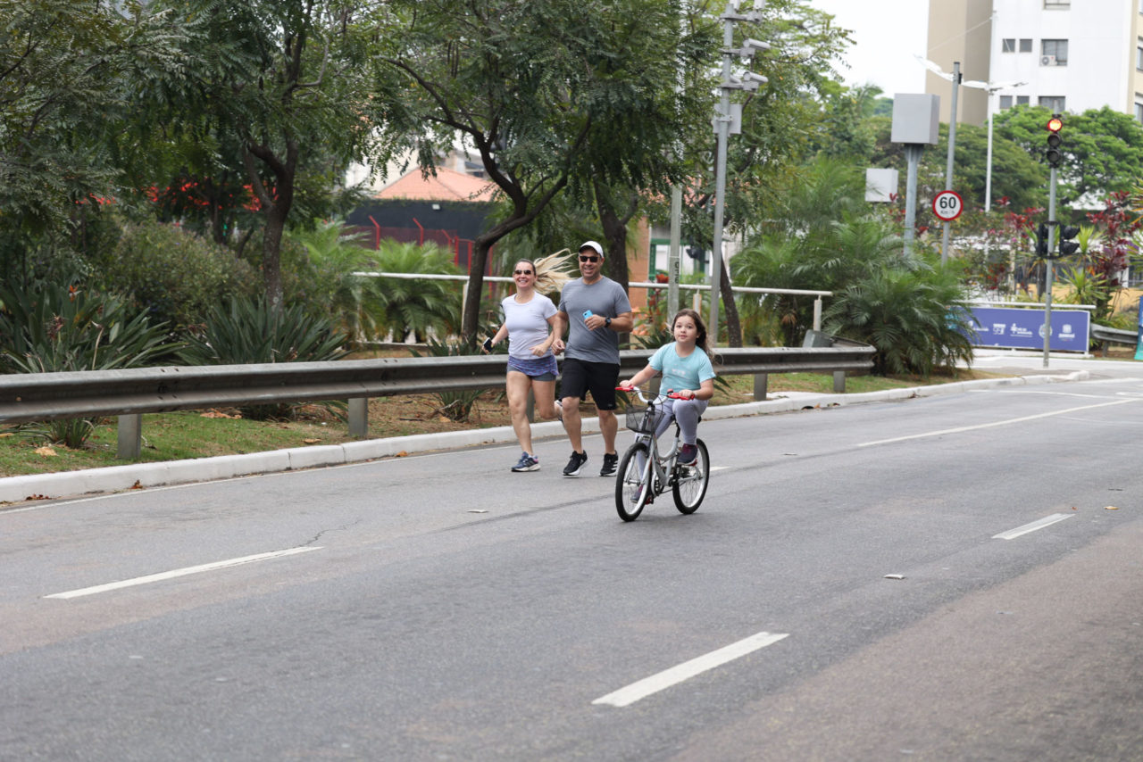Na imagem está uma menina com a bicicleta acompanhada pelos pais, na manhã de domingo, na avenida Nove de Julho.
