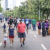 Na imagem estão pessoas caminhando, andando de bicicleta e algumas com os seus cachorros na Avenida Nove de Julho, no lançamento do programa Mobilidade Saudável e Lazer da Prefeitura.