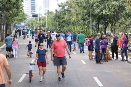 Na imagem estão pessoas caminhando, andando de bicicleta e algumas com os seus cachorros na Avenida Nove de Julho, no lançamento do programa Mobilidade Saudável e Lazer da Prefeitura.