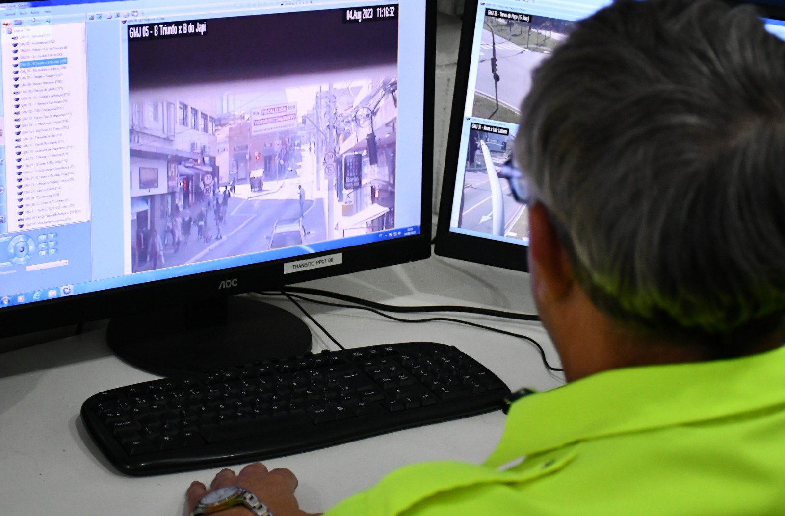 Na imagem está um agente de trânsito em frente a um monitor no centro de controle operacional, e ele monitora a rua Barão do Triunfo que, das 06 às 19h, tem permissão apenas para trânsito de ônibus.