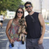 A imagem mostra um casal com um cachorrinho no colo, enquanto caminham pela avenida União dos Ferroviários.