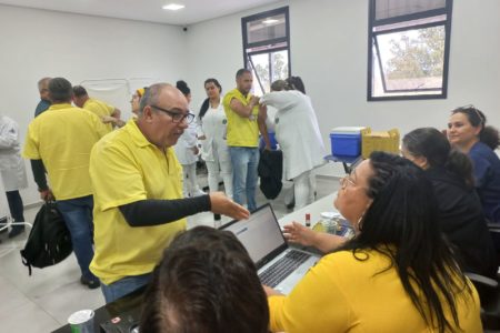 A imagem mostra profissionais da Unidade de Gestão da Saúde da Prefeitura atendendo quatro funcionários das empresas concessionárias de ônibus. Alguns estão tomando vacina e outros recebendo orientações de saúde.
