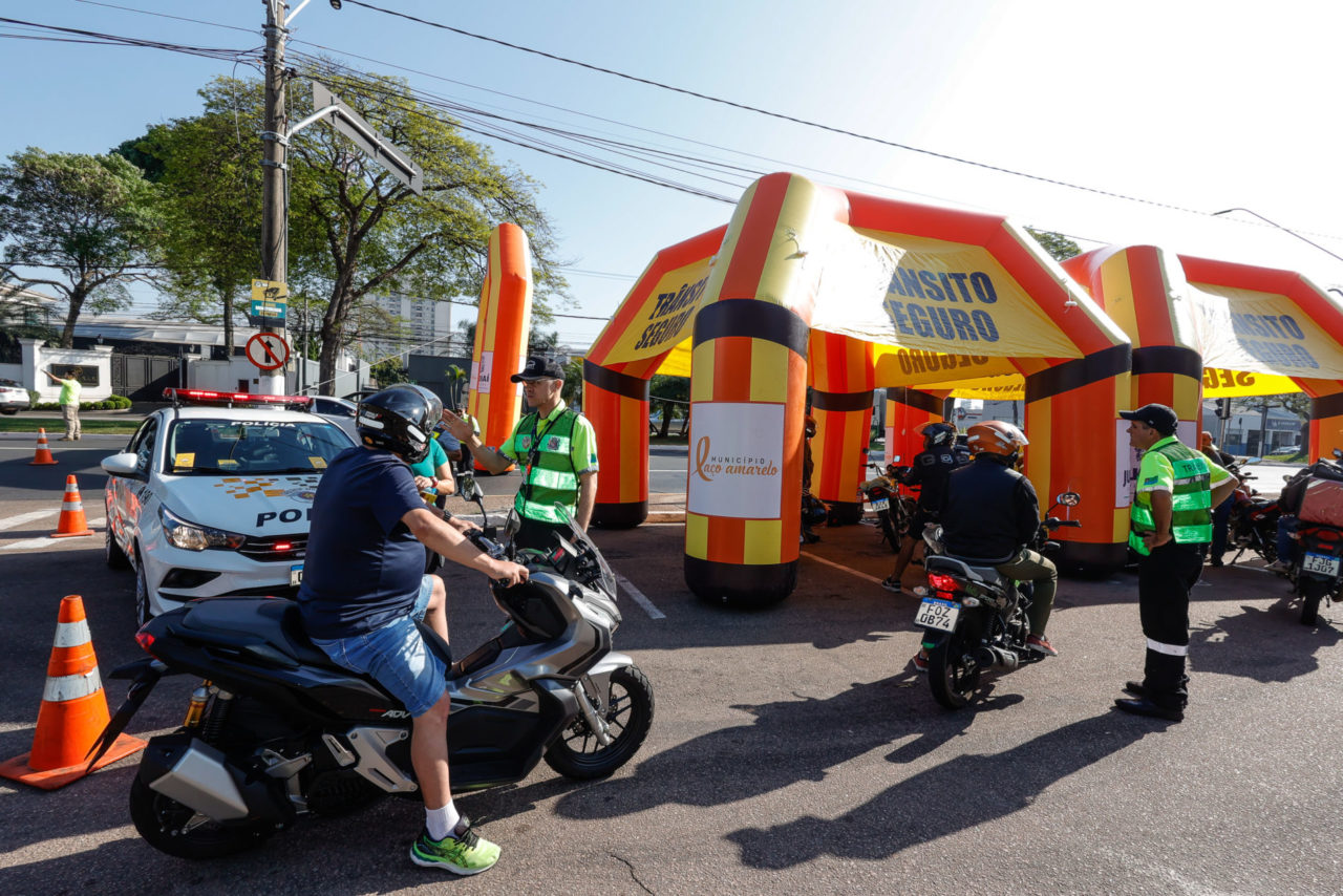 Na imagem há motociclistas recebendo orientações de agentes de trânsito, de equipes da AutoBan, Detran SP, e da Polícia Militar.