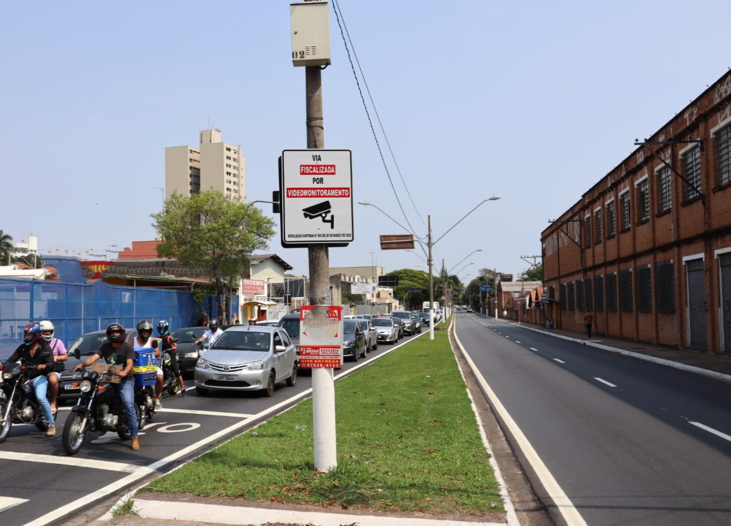 A imagem mostra a Avenida União dos Ferroviários, no trecho do cruzamento com a Rua São Bento, e tem uma poste e uma placa indicando que a via será fiscalizada por videomonitoramento.
