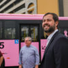 A imagem mostra o prefeito Luiz Fernando Machado em frente ao Paço, e o ônibus rosa e azul atrás